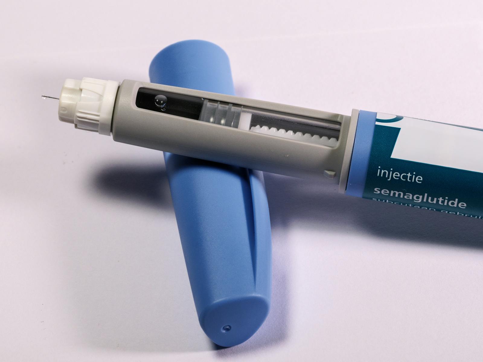 Close-up of a semaglutide injection pen on a plain background