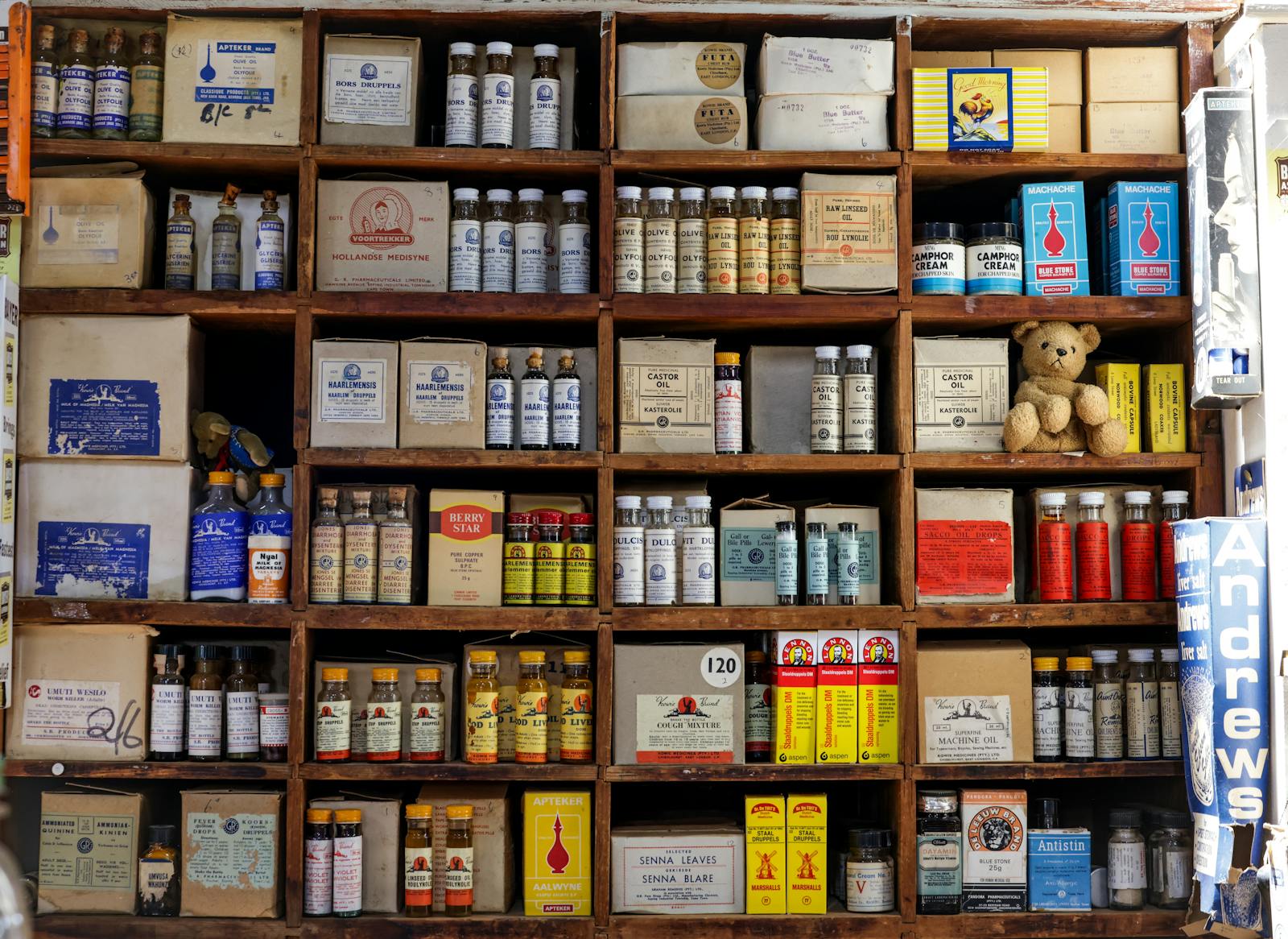 Vintage pharmacy shelf lined with medicine bottles and jars