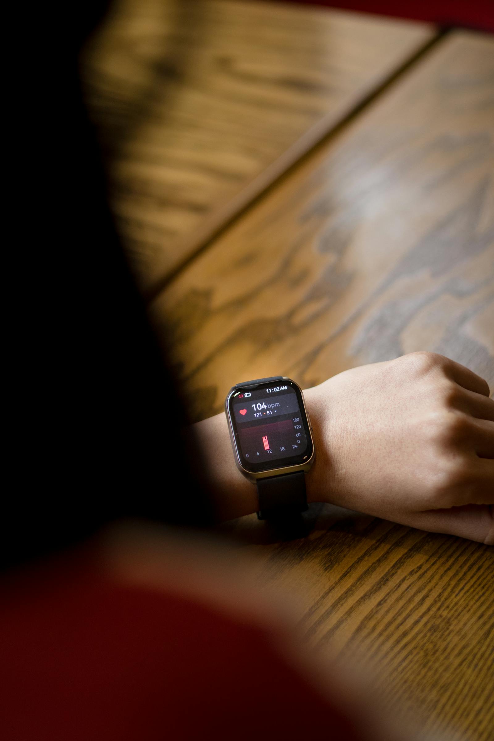Smartwatch on a wrist displaying a heart rate reading
