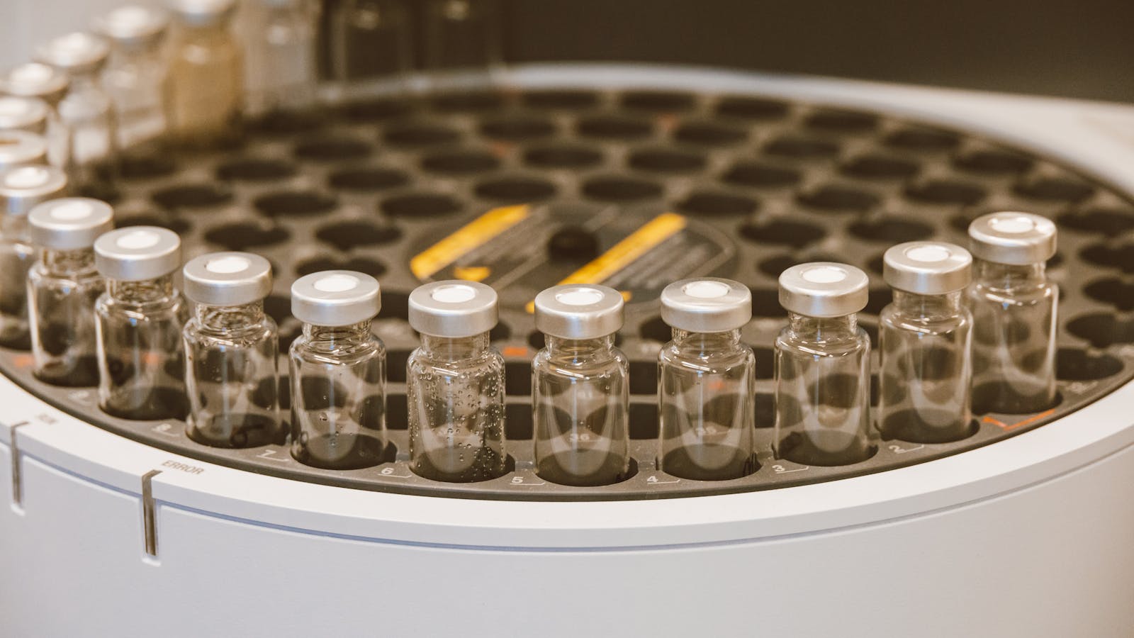 Clear glass laboratory vials arranged in a round container