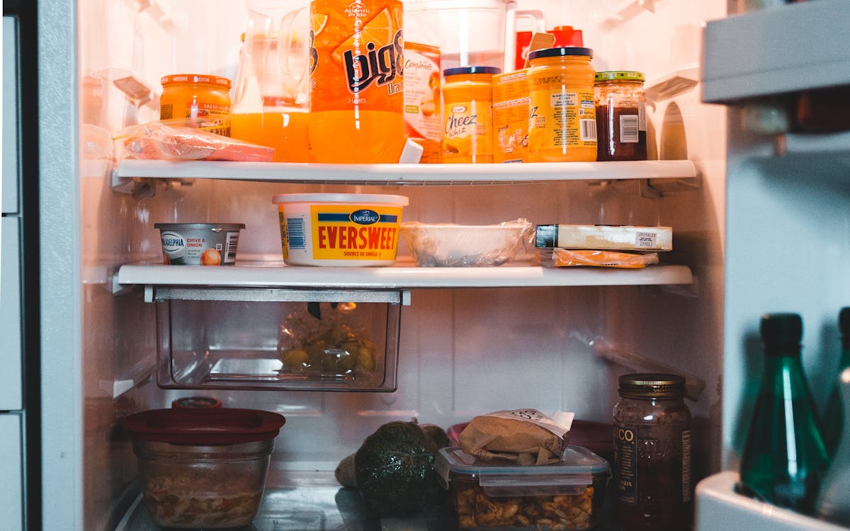 Interior of an opened refrigerator stocked with assorted food and drinks
