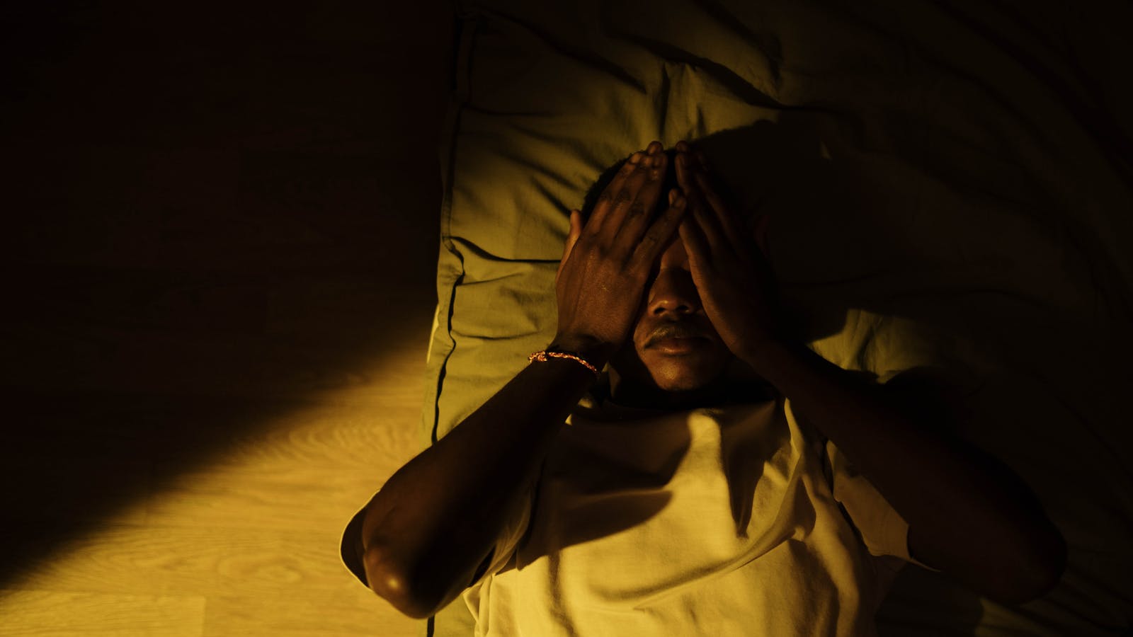 Person lying in bed in a dimly lit room