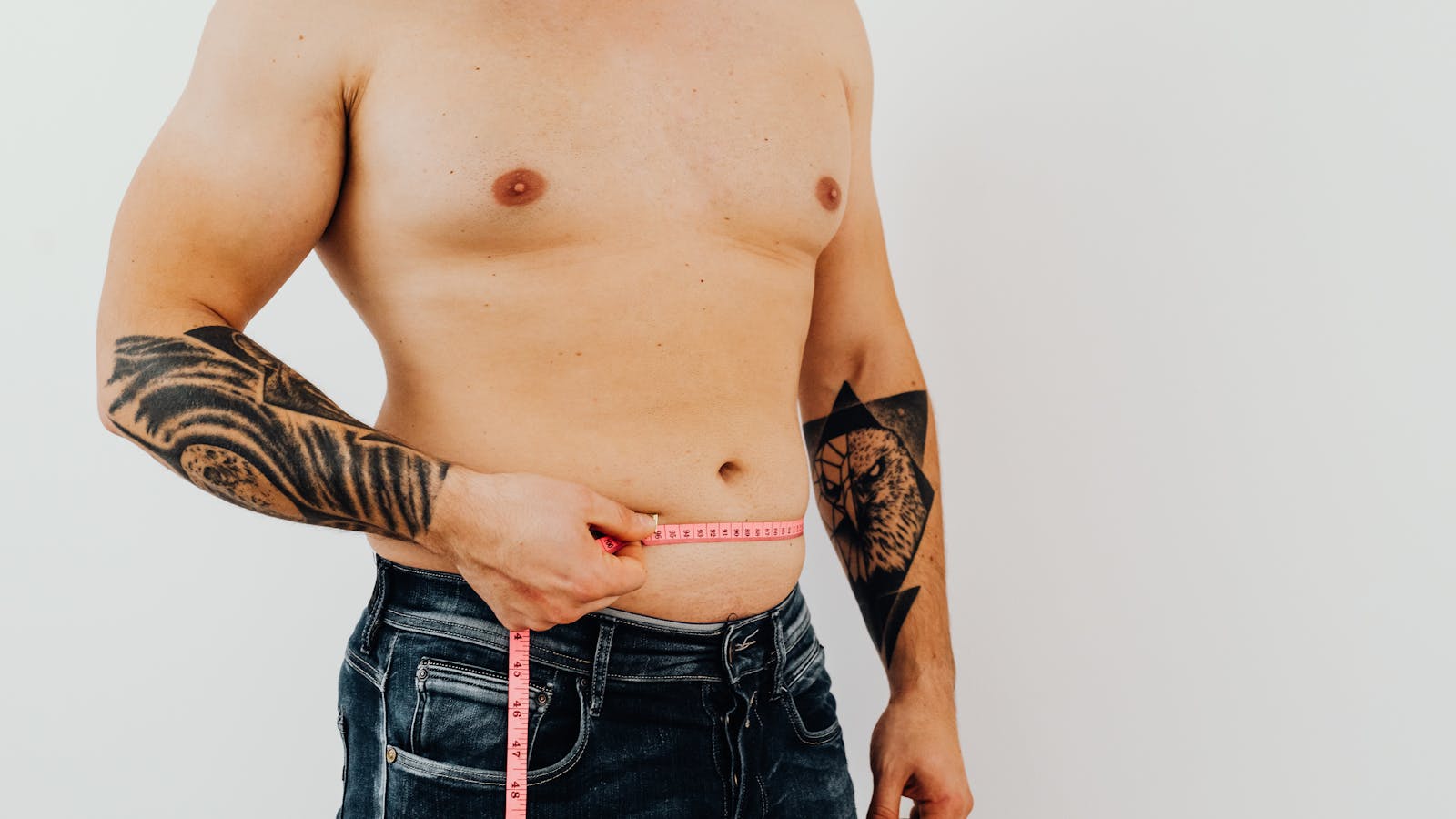 Person measuring their waist with a flexible tape measure