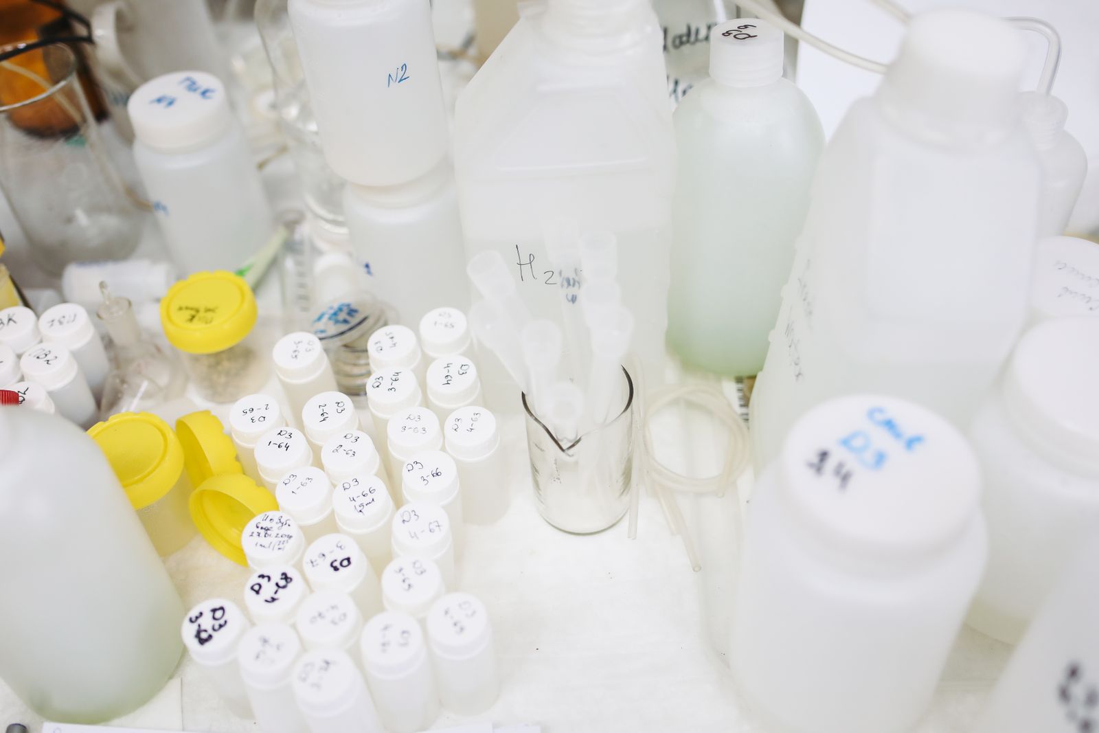 A crowded lab bench covered in dozens of small hand-labelled vials and bottles, evoking research compounds whose labels are handwritten, not approved
